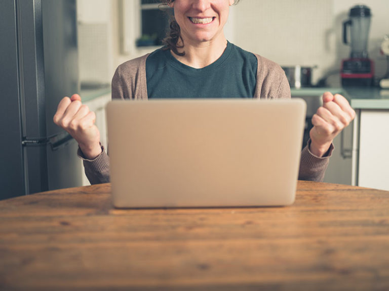 celebrating woman on laptop