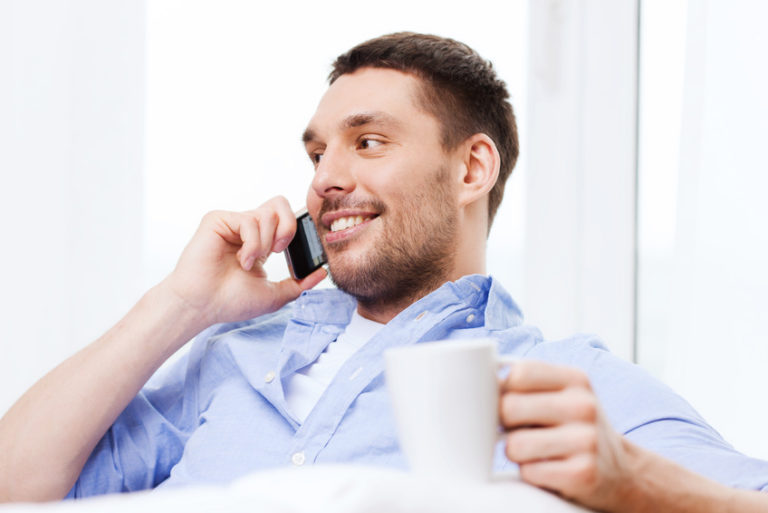 close up of smiling businessman with smartphone