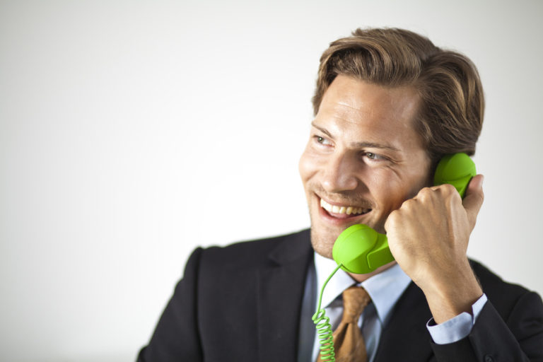 Humorous businessman talking on retro phone