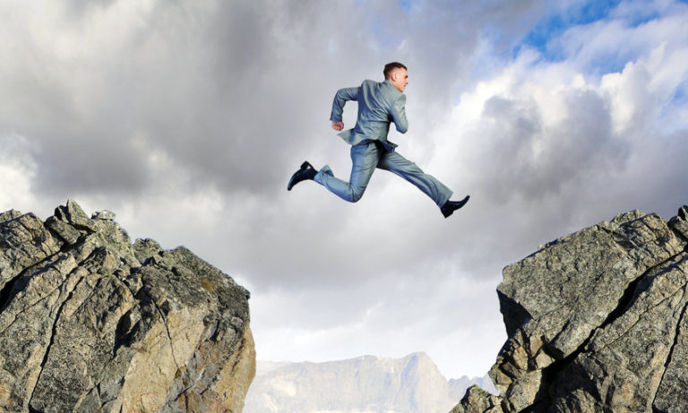 Man jumping from rock to rock representing bridging the skills gap.